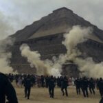 Derecho Chaos Slams South Dakota Crowd of people running near a pyramid with police officers observing