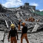 Death Toll War: Models Vs. Regime Rescue workers survey collapsed building debris
