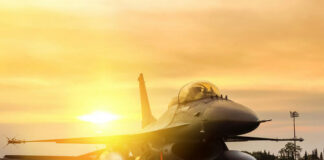 Fighter jet taxiing during sunset on an airstrip.