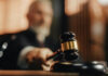 Judge's gavel striking sounding block in courtroom