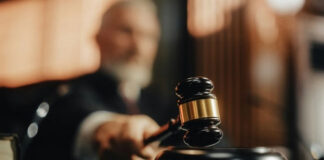 Judge's gavel striking sounding block in courtroom