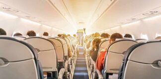 airplane cabin with passengers seated in economy class