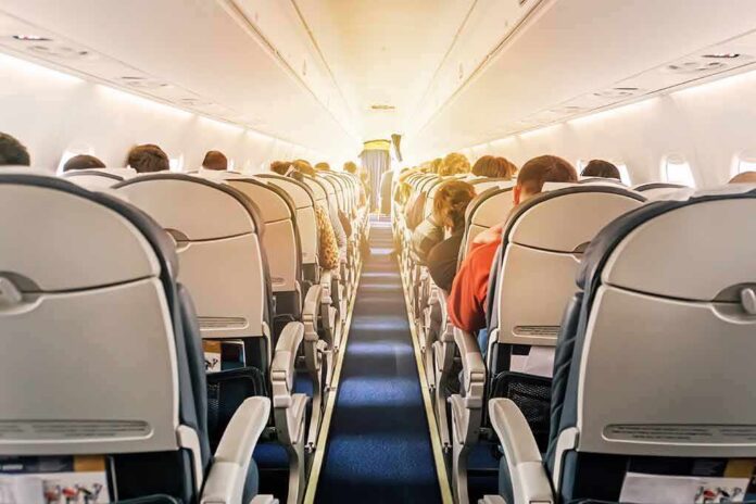 shutterstock_1196036986 airplane cabin with passengers seated in economy class
