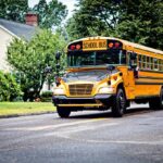Blind Students’ Bus vs. Building — Missing Safeguard? Yellow school bus driving on a suburban street