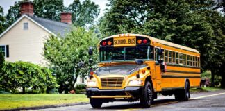 Yellow school bus driving on a suburban street
