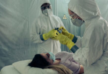 Healthcare workers in protective gear attending to a patient
