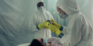 Healthcare workers in protective gear attending to a patient