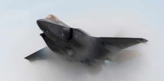 Stealth fighter jet piercing a vapor cloud
