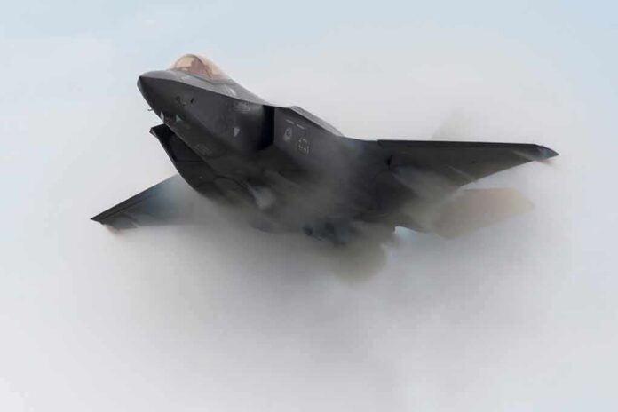 shutterstock_1638650581 Stealth fighter jet piercing a vapor cloud