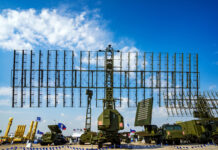 Military radar system displayed at an outdoor exhibition under a blue sky
