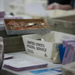 Workers handling mail-in ballots at a postal service.
