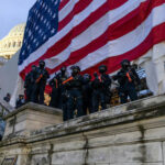 Police in riot gear near U.S. Capitol building.