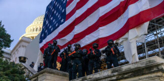 Police in riot gear near U.S. Capitol building.