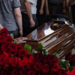 Legacy Or Install? Rotunda Drama Casket surrounded by red roses at a funeral