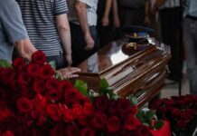 Legacy Or Install? Rotunda Drama Casket surrounded by red roses at a funeral