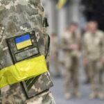 Wartime Purge? Zelensky Axes Chief Soldier in camouflage with Ukrainian flag patch and yellow armband