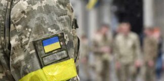 Soldier in camouflage with Ukrainian flag patch and yellow armband