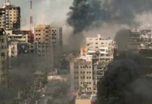 The Safe Zone Paradox in Gaza A cityscape showing damaged buildings and thick smoke rising from the ground