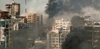A cityscape showing damaged buildings and thick smoke rising from the ground