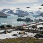 Rescue Dogs and Warships — The Venezuela Operation Raising Real Questions Military personnel and equipment on a snowy beach with helicopters flying overhead