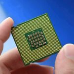 Price Shock Hits AI Optics Close-up of a computer CPU held between fingers