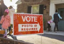 The Voter ID Battle Just Shifted Red voting sign with arrow near people entering a polling place