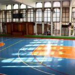 Indoor basketball court with blue floor and orange key areas