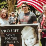 Group of people holding a pro-life sign at an outdoor rally