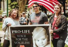 Cafe Showdown Ignites Free Speech Fight Group of people holding a pro-life sign at an outdoor rally