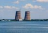 Reactors Idle As River Runs Dry Cooling towers of a power plant by a wide river