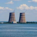 Reactors Idle As River Runs Dry Cooling towers of a power plant by a wide river