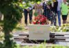Student Medic Killed Mid-Rescue White coffin with red flowers at outdoor burial
