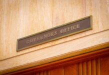 Blue-State Crackdown Meets Defiant Sheriff Governor's Office sign above a wooden doorway