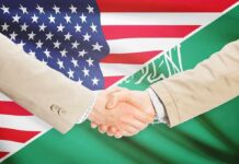 Saudi Leverage Could Gut The Dollar Handshake between two people over U.S. and Saudi flags