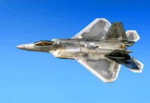 Stealth fighter jet in flight against a clear blue sky
