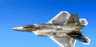 Stealth fighter jet in flight against a clear blue sky