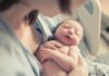 newborn baby sleeping in a parent's arms