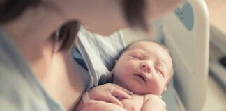 newborn baby sleeping in a parent's arms