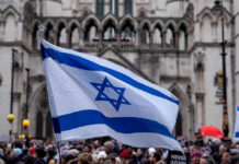 Israeli flag at a crowded outdoor event.