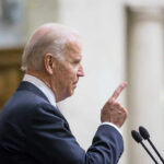 Biden Booed, Then Wanders Offstage Joe Biden speaking at a podium, pointing upward with his index finger