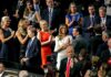 Tiffany Trump, Melania Trump, and Donald Trump Jr. among a crowd applauding at an event