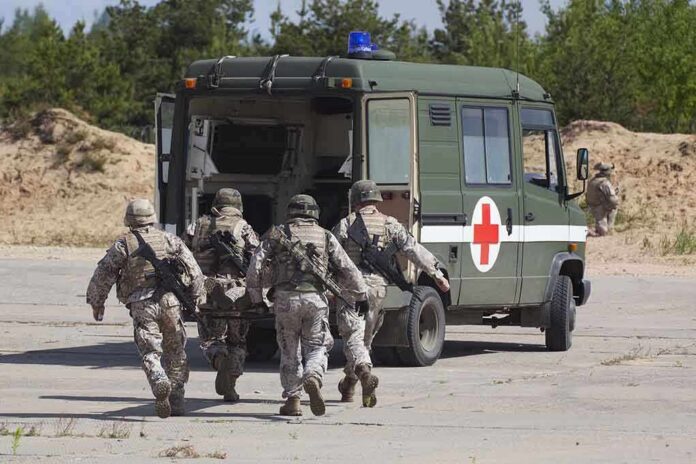 shutterstock_105071369 Soldiers running towards a medical vehicle during a military operation
