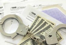 Handcuffs on tax forms with cash