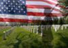 Casualty Gap Mystery – 18 Public, 22 Whispers A military cemetery with white gravestones and an American flag overlay, featuring a soldier silhouette