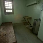Data Blackout Hides Violent Releases Empty jail cell with bed, barred window, and stainless steel toilet