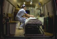 Nurse attending patient on stretcher inside ambulance