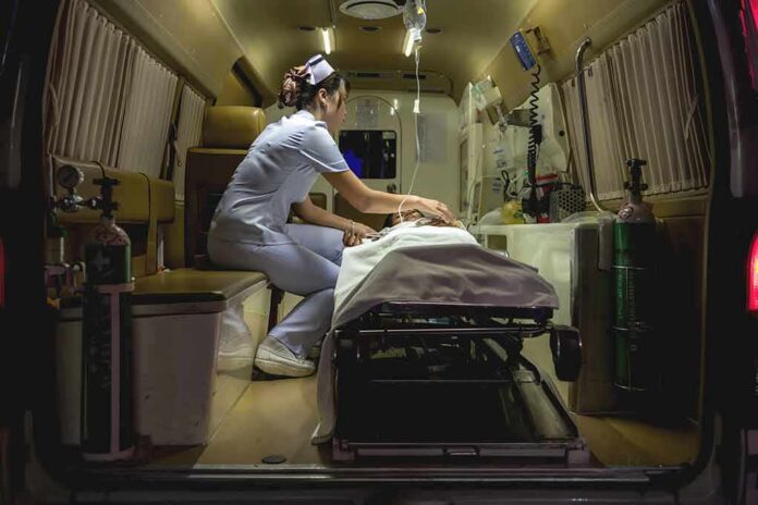 Nurse attending patient on stretcher inside ambulance