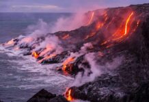 Lava flows entering the ocean along a rugged coastline