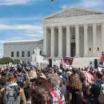 Crowd of protesters outside a neoclassical courthouse