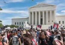 Crowd of protesters outside a neoclassical courthouse